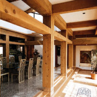 Natural rough cedar beams in a large dining room with table.