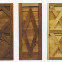 Three wooden shutters in stained from dark to light.